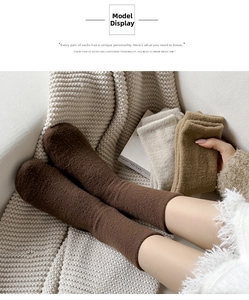 Close-up of thick thermal wool socks in brown and beige tones on a cozy white blanket