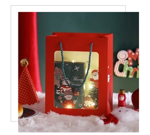 Detail of red Christmas gift bag with clear window, lights, and green spiral handle