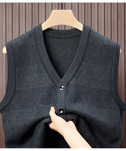 Close-up of charcoal grey knitted vest showing button detail and diamond pattern texture