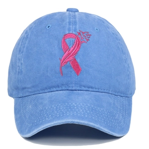 Close-up of pink ribbon embroidery on a blue washed cotton baseball cap texture