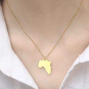 Dettaglio della collana con mappa Africa oro su modella con camicia bianca in stile hiphop