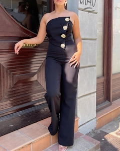 Close-up of black strapless jumpsuit featuring luxury gold buttons on the bodice