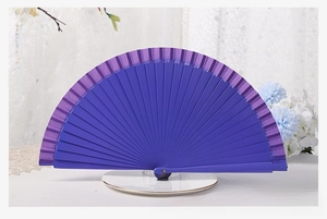 Detail of solid dark purple folding fan showing smooth matte finish and wood texture