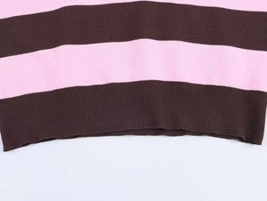 Dettaglio ravvicinato dell'orlo a costine del maglione a righe rosa e marroni