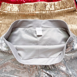 Makrodetail des elastischen Bundes und 100 % Polyester-Waschetiketts an Paillettenshorts
