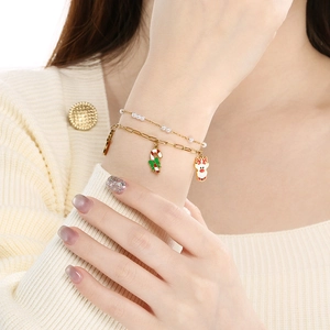 Golden Christmas bracelet with reindeer and candy cane pendants and white pearls for women