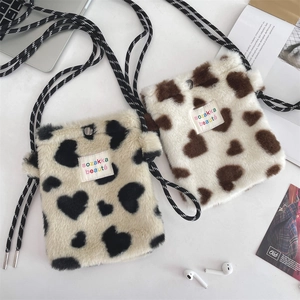 Detail of plush heart pattern shoulder bag with woven strap and snap closure
