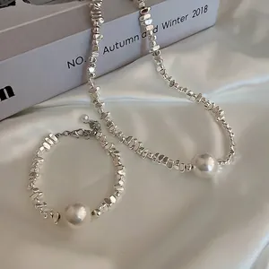 Elegant irregular silver beaded necklace and bracelet set with round white pearls