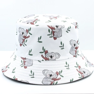 Detail of white reversible bucket hat featuring cute cartoon koala and green leaf prints