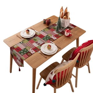 Runner da tavola natalizio con motivi jacquard di alci e fiocchi su un tavolo di legno