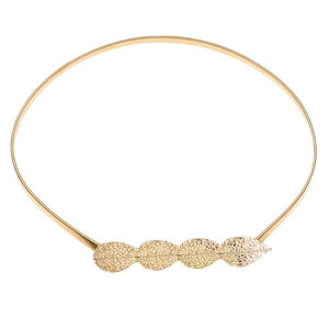 Macro detail of golden elastic metal belt featuring hollowed leaf-shaped buckle design