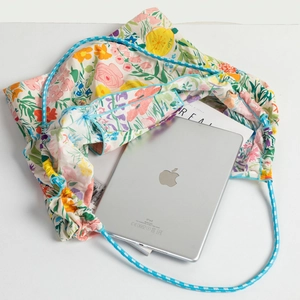 Close-up of floral tote bag with blue drawstring showing internal capacity for an iPad
