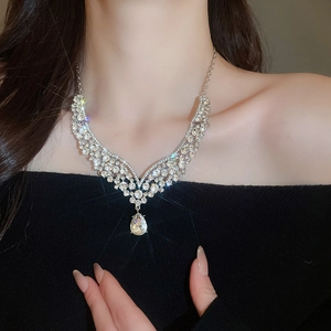Detail of V-shaped rhinestone water drop necklace worn on neck with sparkling finish
