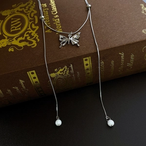 Detailaufnahme einer Zirkon Schmetterling Perlenhalskette auf einem Vintage Buch