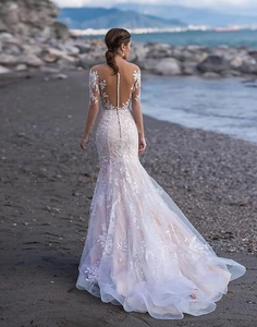 Detail of elegant lace wedding dress featuring deep V back and pearl button accents