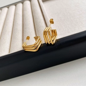 Detailansicht der dreischichtigen goldenen geometrischen Ohrringe mit Spiegelglanz