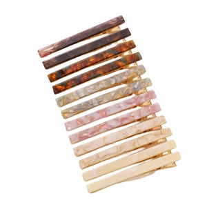 Detail showing 12 acetate hair clips in assorted amber and pastel colors with metal base