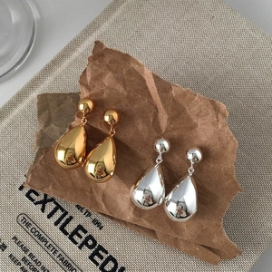 Polished gold and silver teardrop earrings in a minimalist American style aesthetic