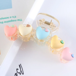Close-up of macaron heart hair claw clip with colorful 3D hearts on white background