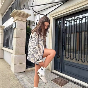 Women's paisley print quilted jacket styled with cozy socks and felt clogs outdoors
