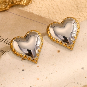 Macro shot of two-tone heart stud earrings with silver center and textured gold border