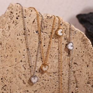 Détail du collier cœur en or 18K avec nacre et zircons sur fond de pierre naturelle