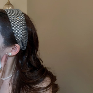 Close-up of wide rhinestone headband and pearl earrings on female model in bright silver