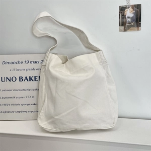 Dettaglio di una grande borsa tote in tela bianca con tracolla larga e piatta