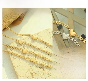 Detail of heart pendants in gold and silver on stone and wood with cuban chains