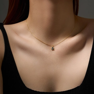 Detail of a gold S925 sterling silver necklace featuring a blue pear-shaped zircon pendant