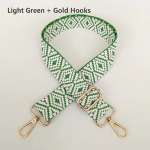 Detail of adjustable geometric weave bag strap with gold metal hooks in light green