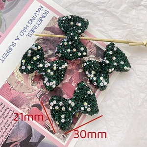 Detailed view of emerald bow rhinestone charms sized 30mm by 21mm for DIY jewelry
