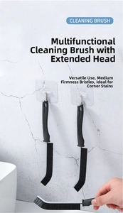 Close-up of a long-handle crevice cleaning brush with stiff black bristles for bathroom tile