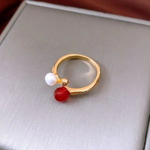 Detail eines vergoldeten Wellenrings mit einer Süßwasserperle und rotem Achat