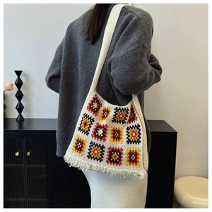 Detail of granny square crochet tote bag featuring vintage patterns and long fringe tassels
