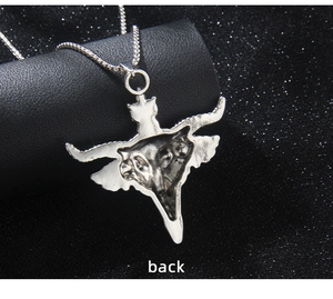 Close-up of butterfly pendant back with skull detail and silver chain on dark background