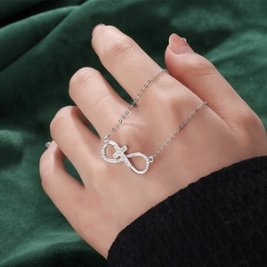 Collier croix infini en argent S925 avec zircons sur fond élégant en velours vert