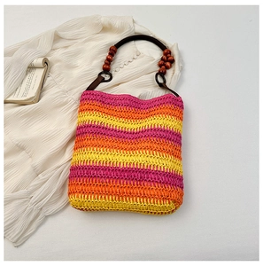 Detail of rainbow straw bucket bag with pink, orange, yellow stripes and wood bead handles