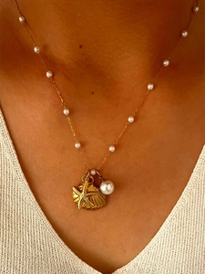 Detail of gold starfish shell and large pearl pendant set on a delicate link chain