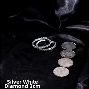 Detail of 3cm silver crystal hoop earrings with white rhinestones on black silk fabric