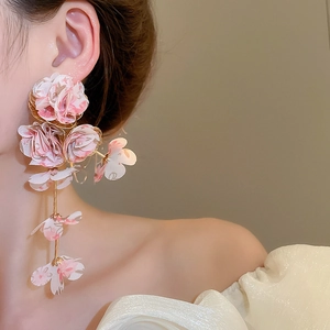 Detail view of pink chiffon flower fringe earrings on model for beach vacation style