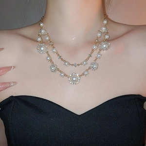 Detailed view of elegant double-layered pearl necklace with diamond-set sun flower pendant