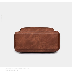 Detailed bottom view of brown leather backpack showing fine texture and stitching