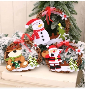 Detail of Christmas rattan wreath featuring felt reindeer and snowman on pine branch