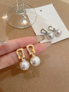Detailed view of 18K gold plated horseshoe earrings with pearls and zircon stones