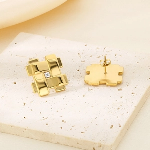 Boucles d'oreilles dorées géométriques avec cristal carré sur socle en pierre esthétique