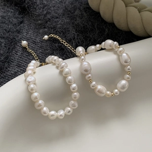 Baroque freshwater pearl bracelet with gold-plated chain on minimalist ceramic dish
