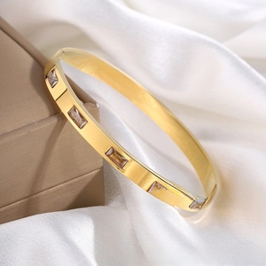 Macro view of 18K gold-plated titanium steel bangle set with five square zircons
