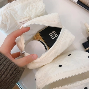 Vue détaillée de la trousse de maquillage matelassée blanc crème au fini diamanté