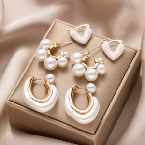 Detailed macro view of three gold earring sets with pearls on elegant gold jewelry box